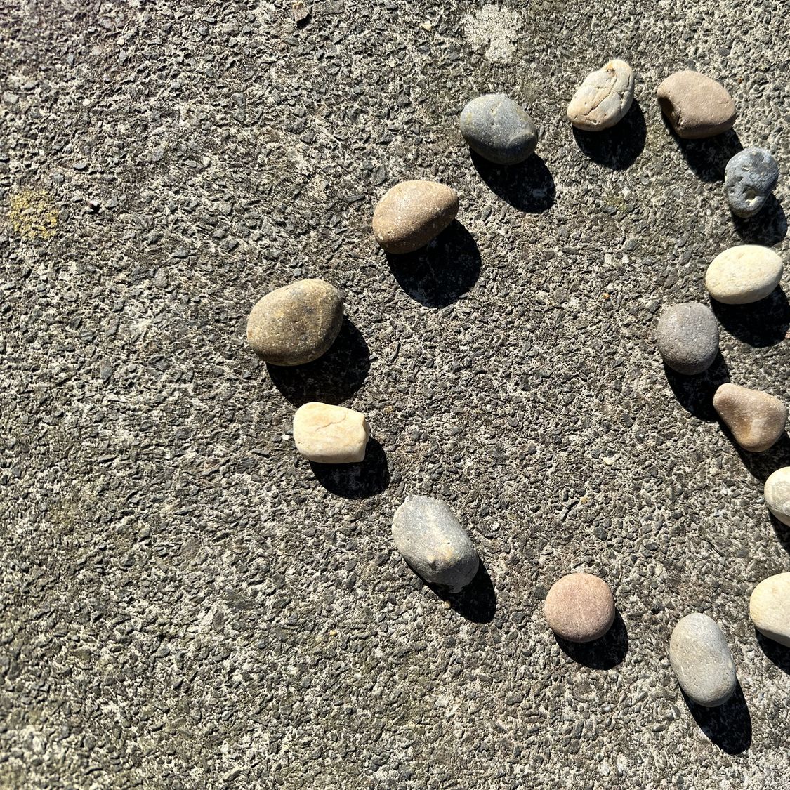 Petites pierres disposées en forme de cœur sur le sable d’une plage, symbole d’une rencontre après 50 ans, d’une relation durable et d’un amour partagé.
